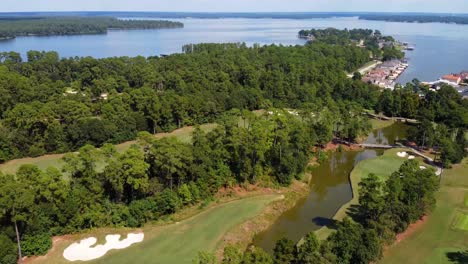 a drone shot panning over a golf course, located by a body of water, recorded at 6o frames
