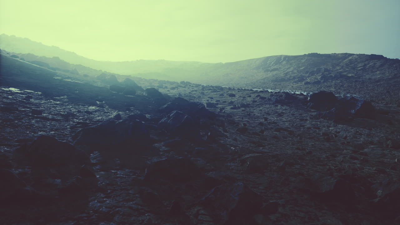 Dramatic landscape with rocky terrain under a hazy sky at dusk