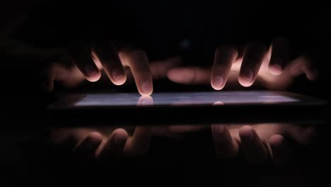 hands using a tablet in the dark