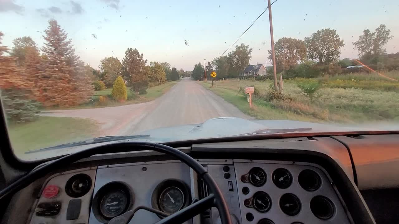 pov conduciendo un viejo camión de basura por un camino de tierra accidentado en el campo de américa