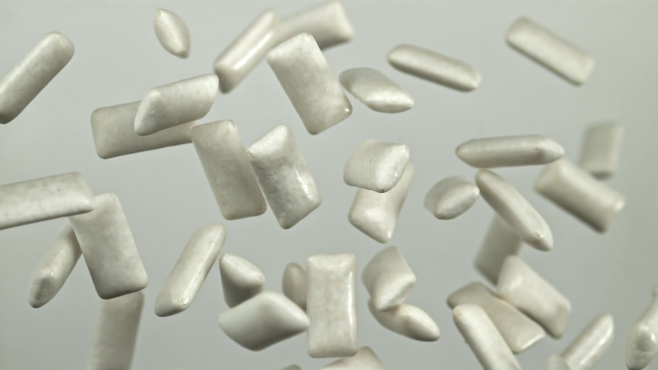 Pedaços de chiclete branco flutuando em câmera lenta