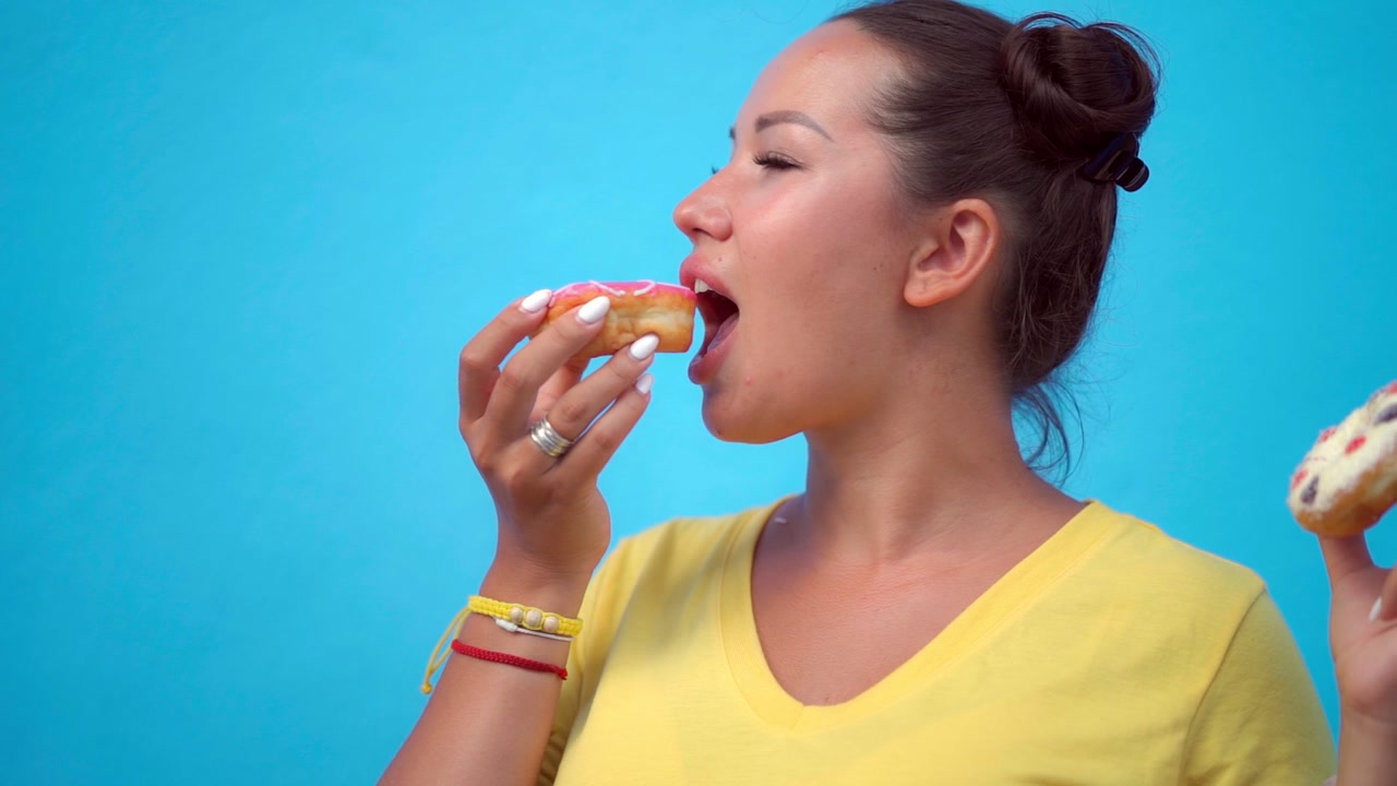 Young Woman Choosing Between Two Different Donuts