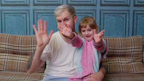 padre y pequeña hija hija sonriendo, saludando alegremente, saludando hola, hola, bienvenidos juntos