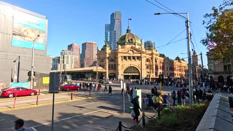 people crossing street near iconic station