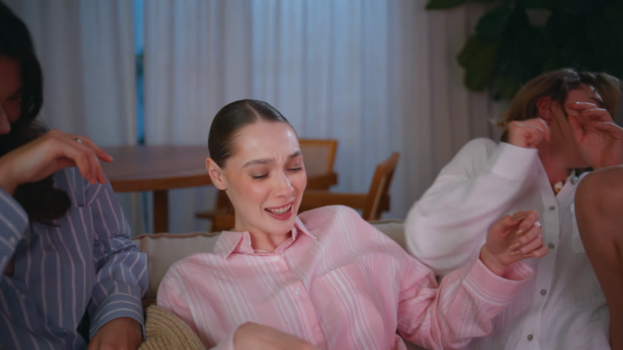 Smiling ladies having fun fooling together at evening couch closeup. Happy women