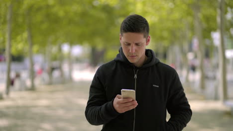 Man-using-smartphone-and-walking-on-street