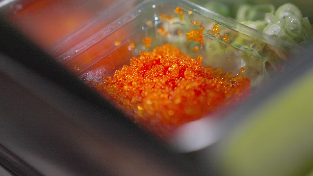 A roaming macro shot capturing the fine details of fish eggs and other sushi ingredients, highlighting their textures, colors, and freshness for culinary preparation.