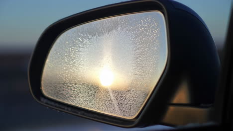 frosted car side mirror reflecting the sun