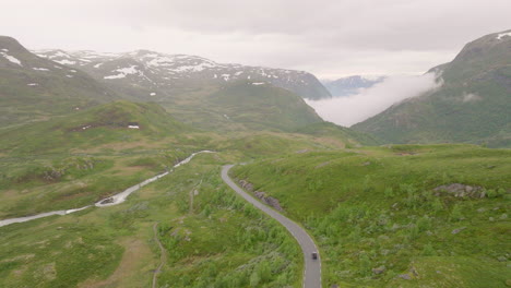 car drives along scenic sognefjellsvegen, norwegian alpine landscape