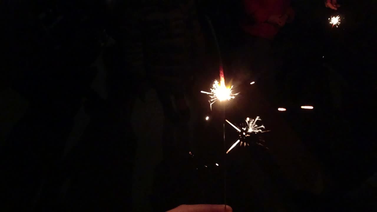 Celebrazione festiva con stelle filanti che bruciano nell'oscurità. Ripresa al rallentatore.