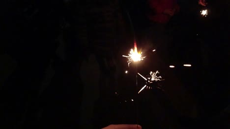 holiday celebration with sparklers burning in the darkness. slow motion shot.