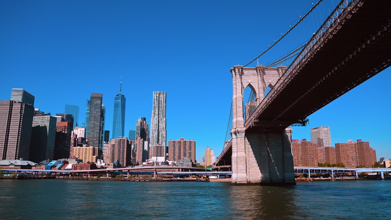 New York, USA, 5 dicembre 2025: Ponte di Brooklyn sul fiume East River, skyline di Manhattan e cielo azzurro limpido. Vista panoramica del ponte di Brooklyn che attraversa l'East River