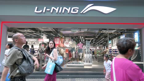 pedestrians walk past li-ning, the chinese sportswear and sports equipment company, in hong kong, china.