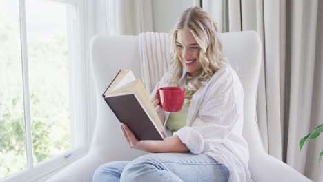 retrato de una feliz mujer caucásica de talla grande leyendo un libro y bebiendo café