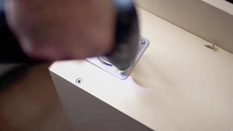 screwing the screw into the table surface with a screwdriver 2