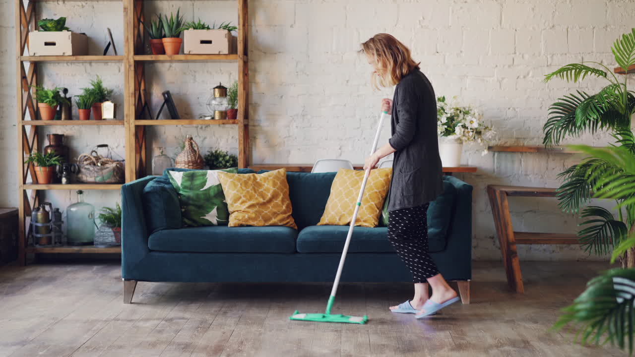 Woman Mopping Floor in a Cozy Living Room