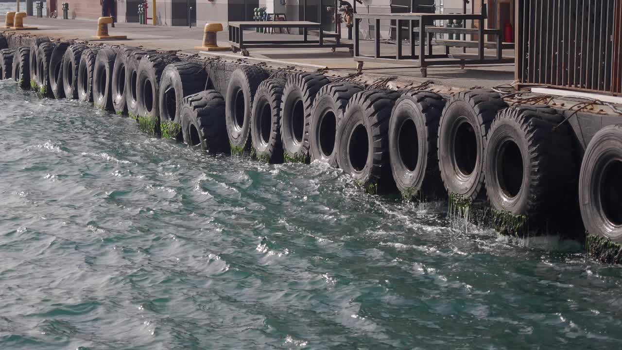 앞면 에 물 이 있는 도크 를 가로지르는 타이어 의 줄