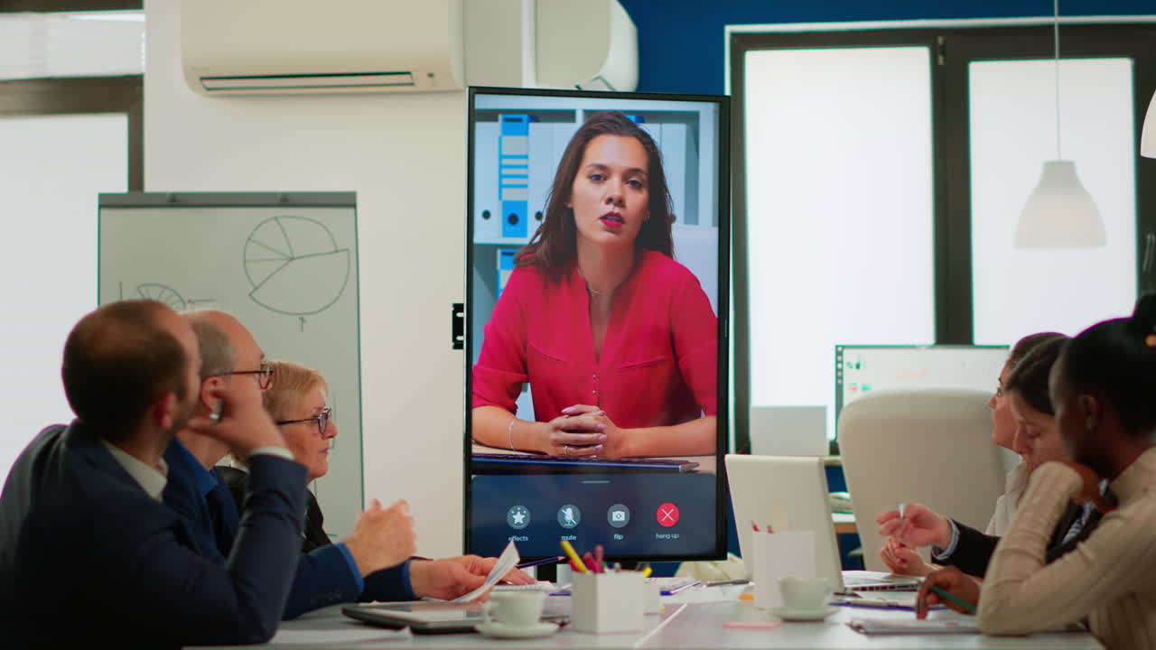 Diverse executive team meeting at conference video call looking at huge display