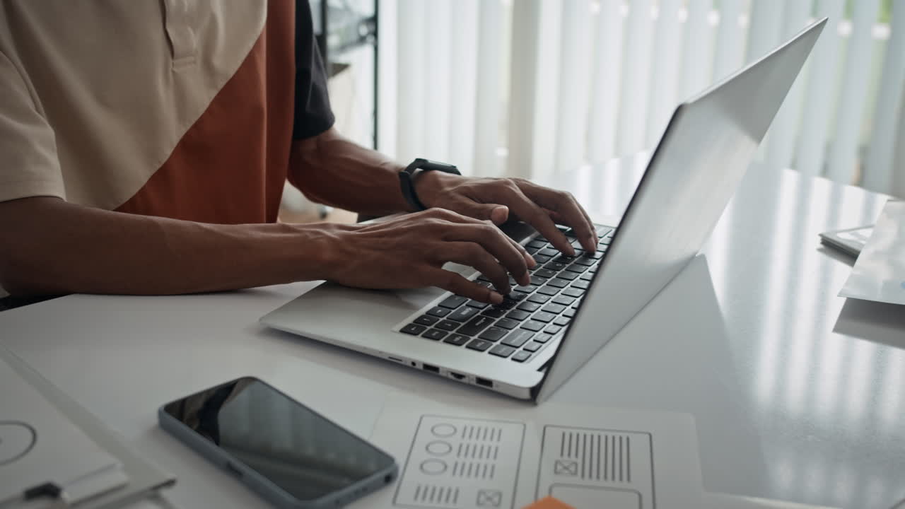 Anonymous Manager Filling Documents on Laptop at Office