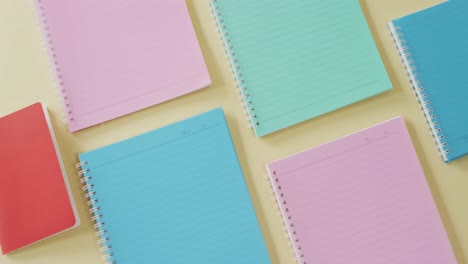 video of composition with colorful notebooks on yellow surface