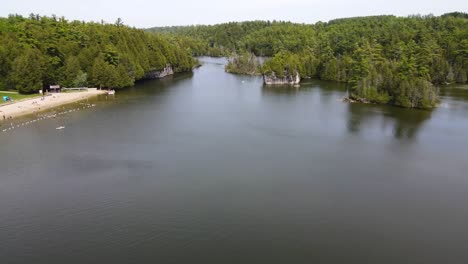 Drone-Volando-Sobre-Un-Lago-Y-Una-Playa-En-Guelph