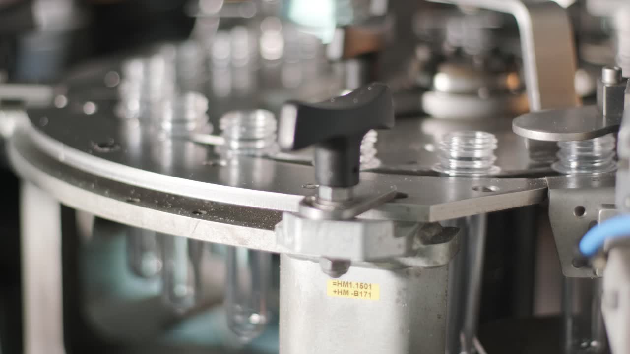 Automatic filling machine pours water into plastic PET bottles at modern beverage plant