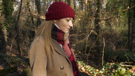 Tracking-shot-of-young-blond-woman-walks-alone-in-beech-forest