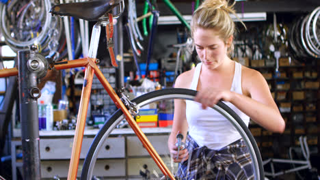 woman oiling bicycle at workshop 4k