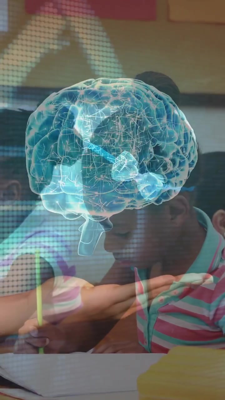 Vertical video: Teacher holding 3D brain above class as boy writing, revealing neural map to teach