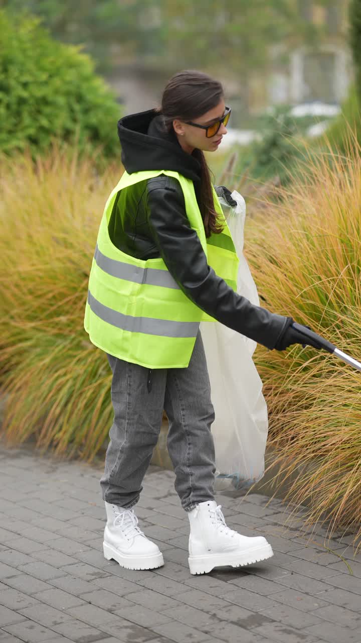 mujer limpiando la basura en un parque de la ciudad