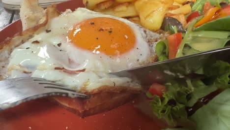 comer una rebanada de pan de carne y huevo frito con ensalada cerca de comer desordenado