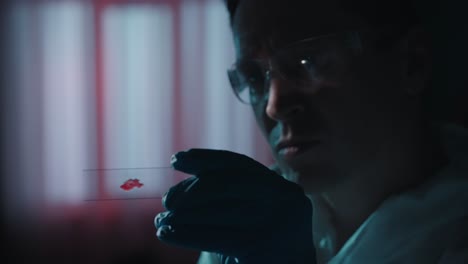 scientist examining blood sample under microscope