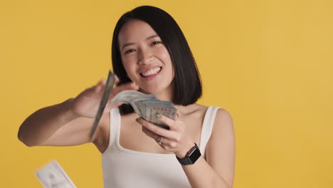 asian woman throwing money on camera.