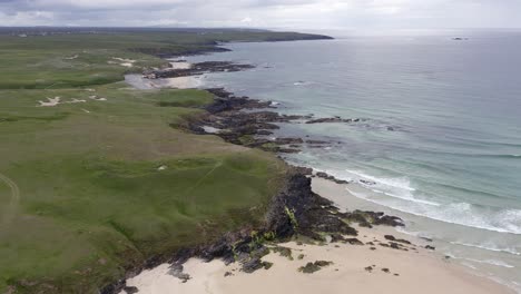 drone shot of eoropie beach in ness and the headland beyond it on a sunny, summer's day