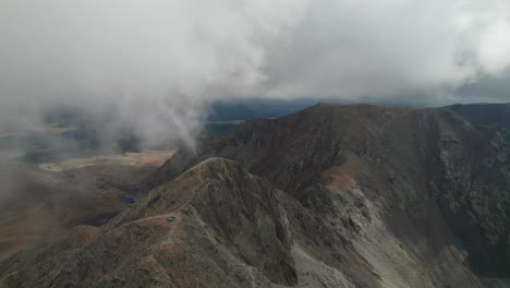 Vista-Aérea-Del-Pico-De-La-Montaña-Carlit-Con-Nubes-En-Movimiento-Durante-El-Otoño-En-Los-Pirineos-Franceses