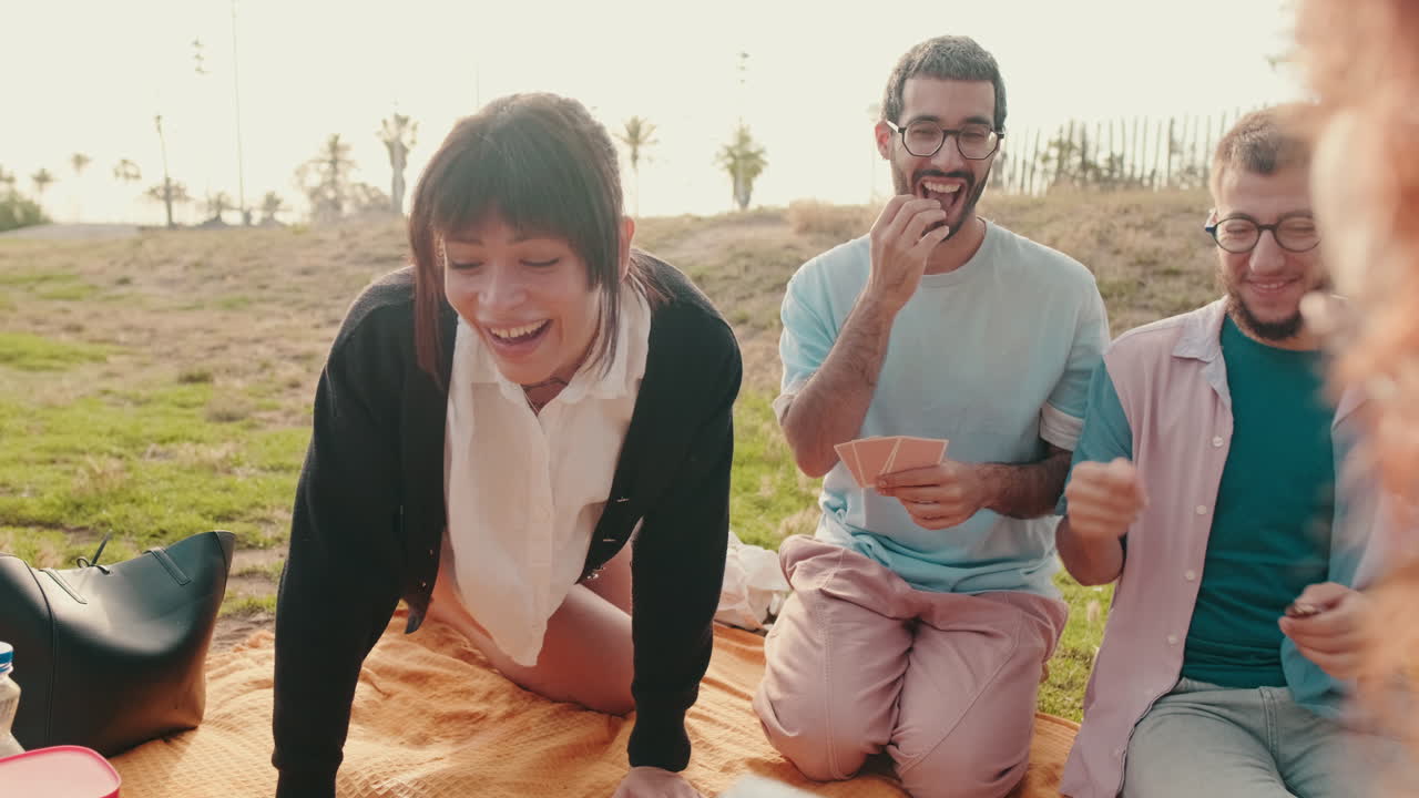 Friends Enjoy a Picnic and Play Cards