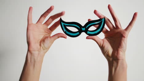 hands holding a party mask