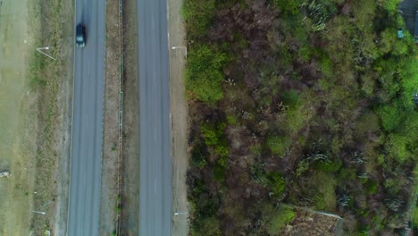 Die-Drohne-Von-Oben-Nach-Unten-Folgt-Der-Autobahnstraße-Auf-Einem-Tropischen-Hügel,-Aus-Der-Vogelperspektive