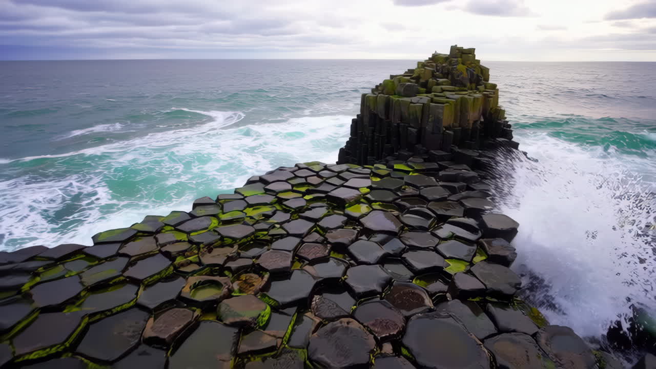 Dynamiske bølger, der slår ind over sekskantede basaltsøjler ved Giant's Causeway