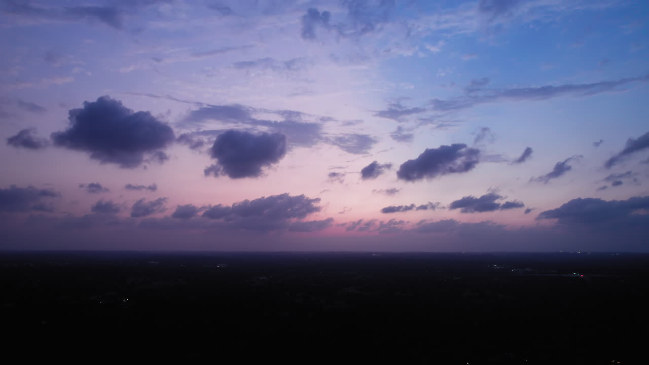 Colorful Blue Hour cloudscape over a Texas Suburb near Austin with lights in the distance
