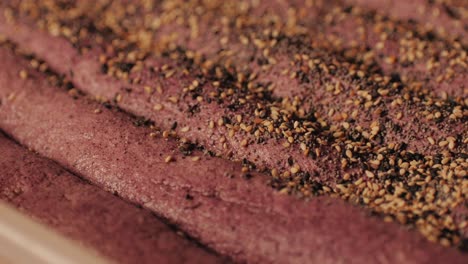 bakery chef making fresh artesian buns and baguettes using traditional recipe close-up. young man kneading dough. artisan bread is making by skill bakers using natural and high-quality ingredients. food with health and flavour benefits. bakery shop and market