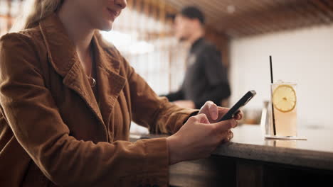 mujer usando el teléfono en un bar
