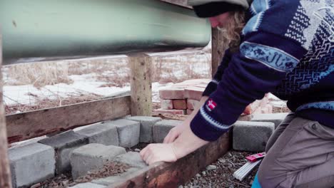 diy hot tub making, man using level to secure the foundation