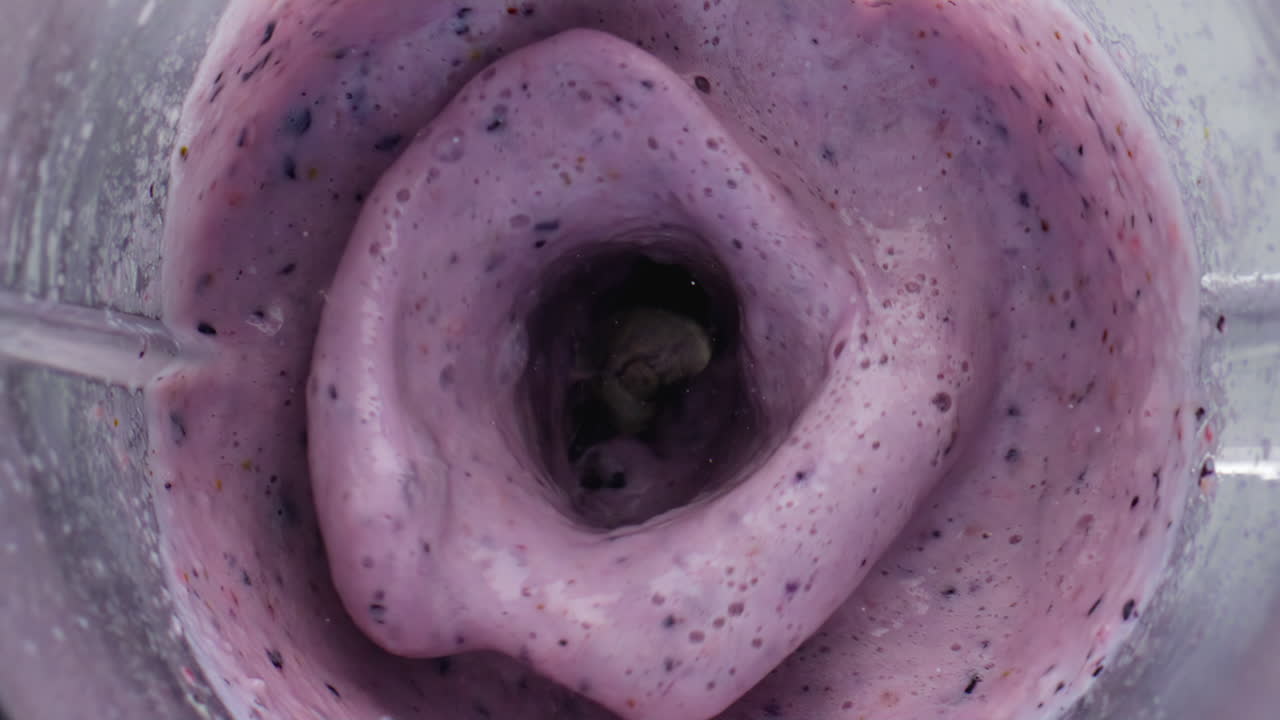 coctel de leche de bayas frescas mezclando el cuenco de la licuadora en súper cámara lenta de cerca.