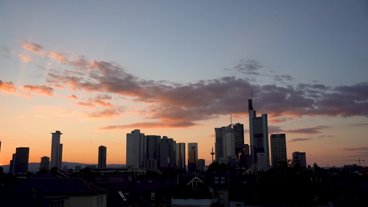 Atardecer sobre el horizonte de Fráncfort con nubes dramáticas, siluetas de rascacielos