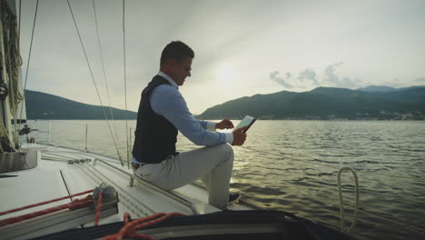 businessman working on a tablet on a sailboat