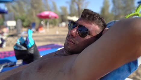 a man lounging on a beach chair while relaxing on a beach