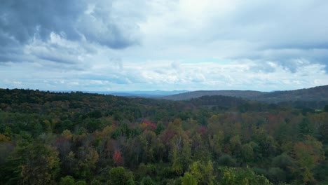 drone flight on a rainy day over the woods in colorful fall foliage in western massachusetts