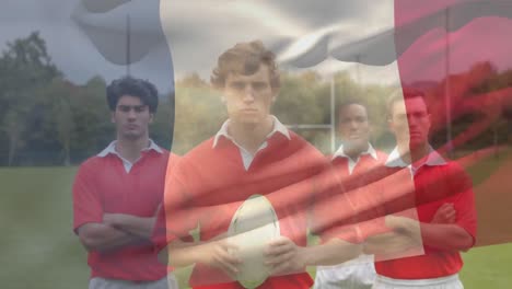 Equipo-De-Rugby-De-Pie-Y-Mirando-A-La-Cámara-Con-Una-Bandera-Francesa-En-El-Fondo