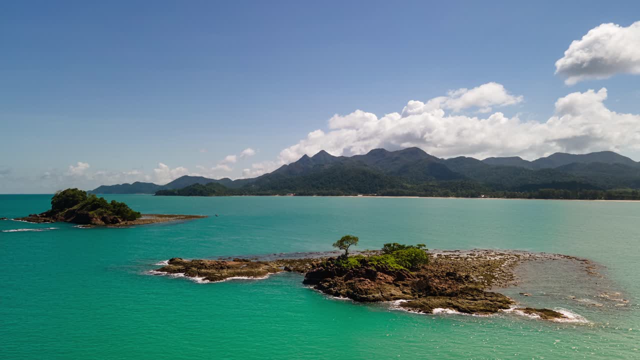 4K Timelapse Aerial Drone Footage Static Hovering Shot of small Islands with Blue Skies, Turquoise Waters and Koh Chang Island in the background
